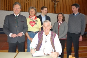 Father Shay Cullen while writing in the guestbook of the parish Ainring with (starting on the left) Mayour Hans Eschlberger, Rosi Pscheidl from the Worldshop, councilman Jörg Mader, speaker Birgit Weber and priest Wernher Bien.