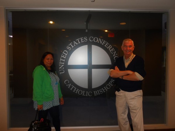 Father Shay and Marlyn Capio-Richter poise a the  crest of  the  United States conference of catholic Bishops  after each made a presentation  on human trafficking  and children in jails  before  a meeting of high ranking conferenc