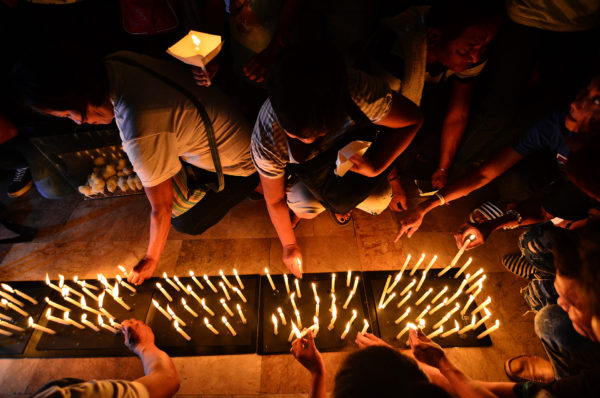 REMEMBERING THE DEAD. Relatives of victims of extrajudicial killings light candles in a prayer service at the Caloocan Cathedral on October 24, 2017. Photo by Maria Tan/Rapplerc