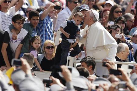 Pope Francis kisses a child as he arrives to lead his Wednesday general audience in Saint Peter's Square at the Vatican June 5, 2013. REUTERS/Max Rossi